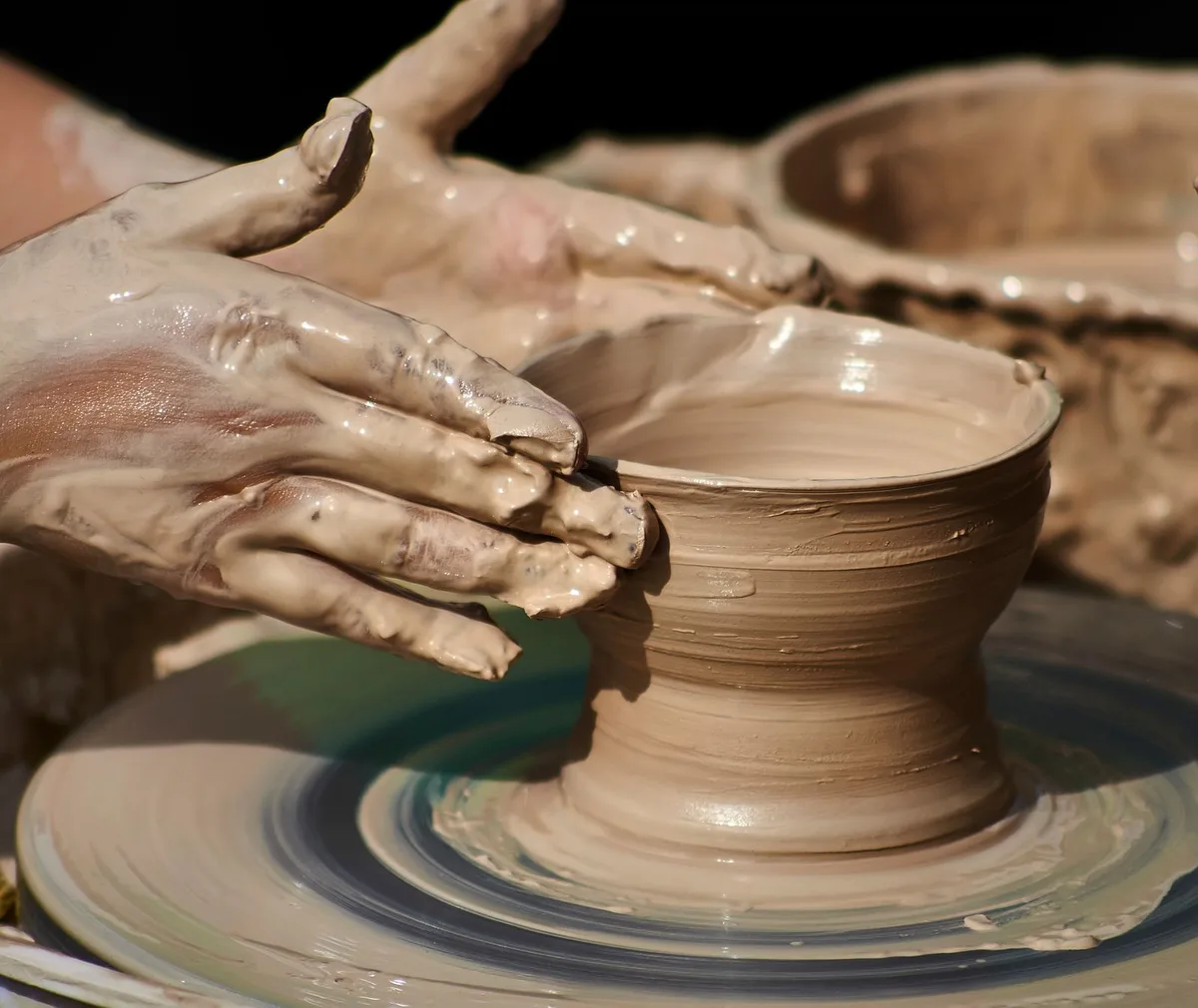 Close-up of hands shaping pottery on a wheel