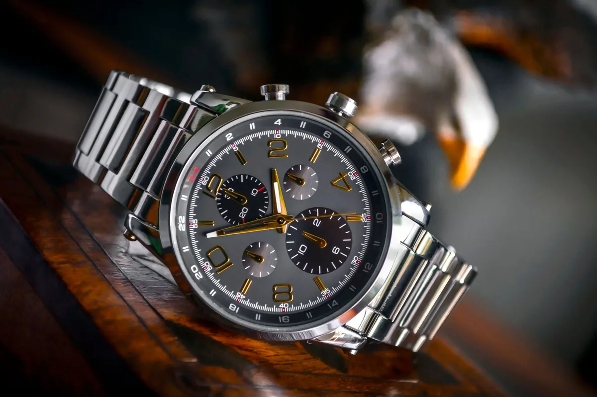 Luxury wristwatch with steel bracelet on wood