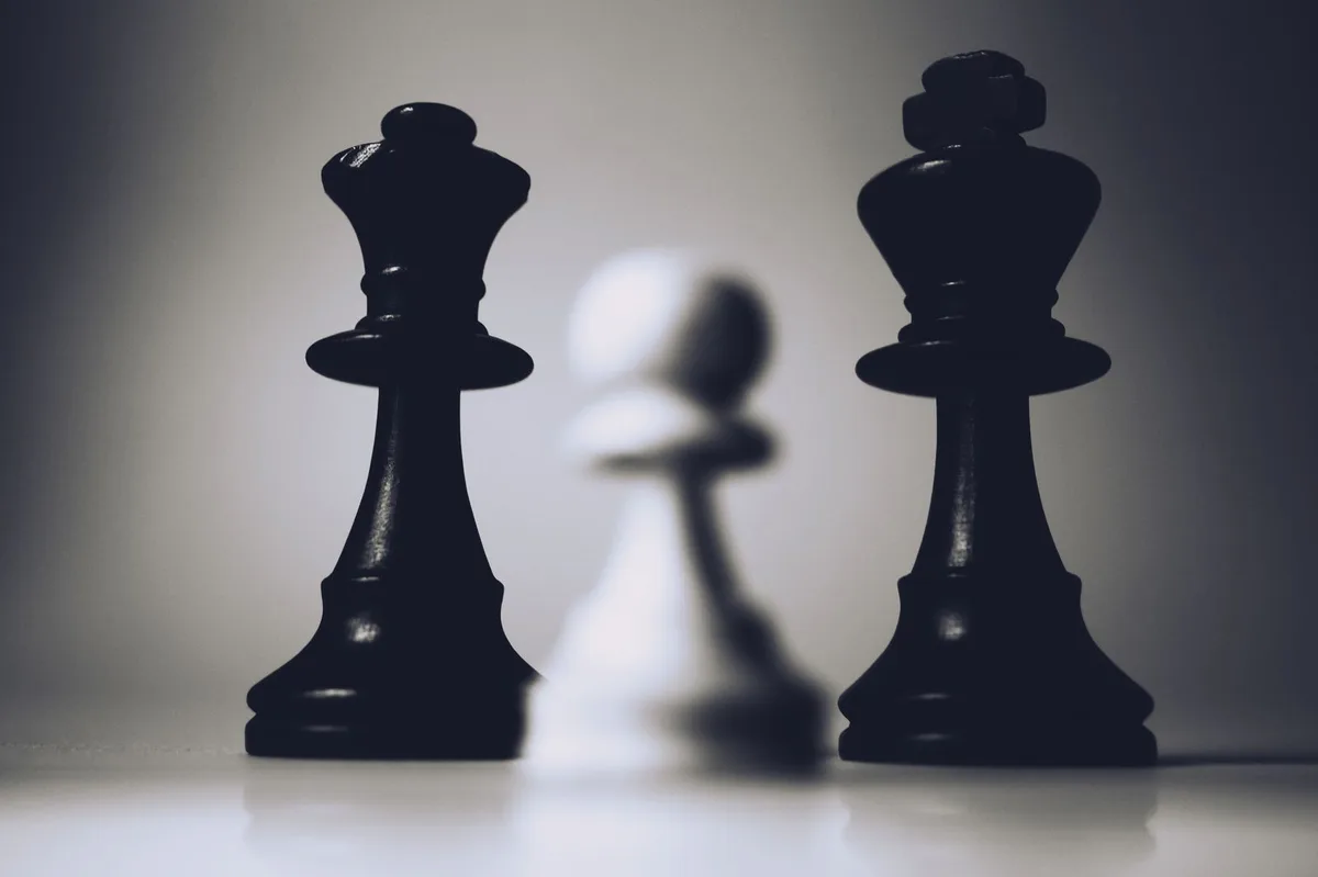Chess king and pawn in dramatic lighting