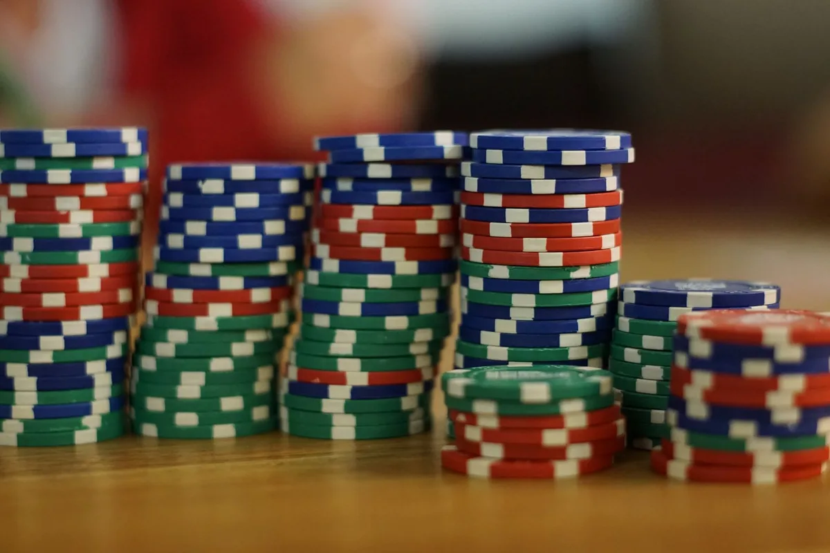 Colorful stacked poker chips on a wooden table