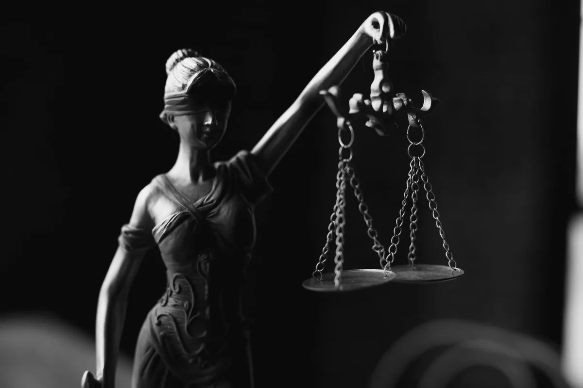 Black and white Lady Justice figurine with scales