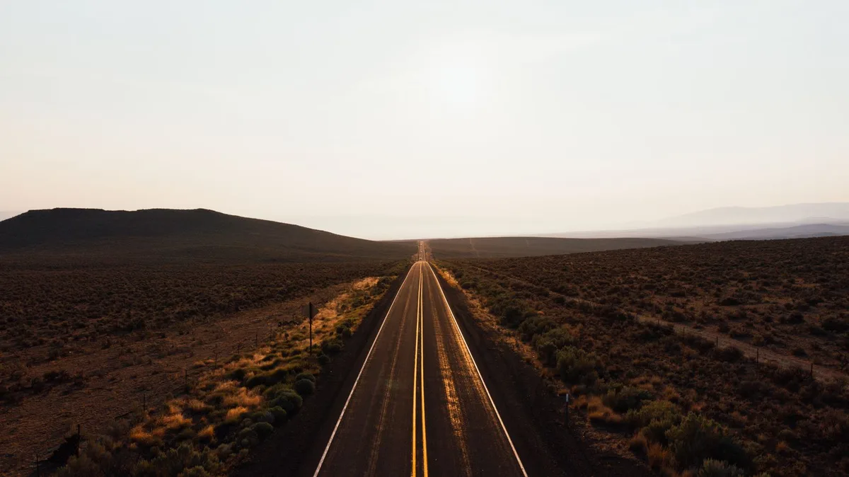 Aerial view of a desert highway at sunrise